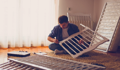 A father trying to fix a used crib.